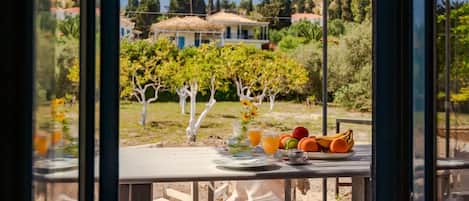 A table with breakfast items and a view of a vineyard.