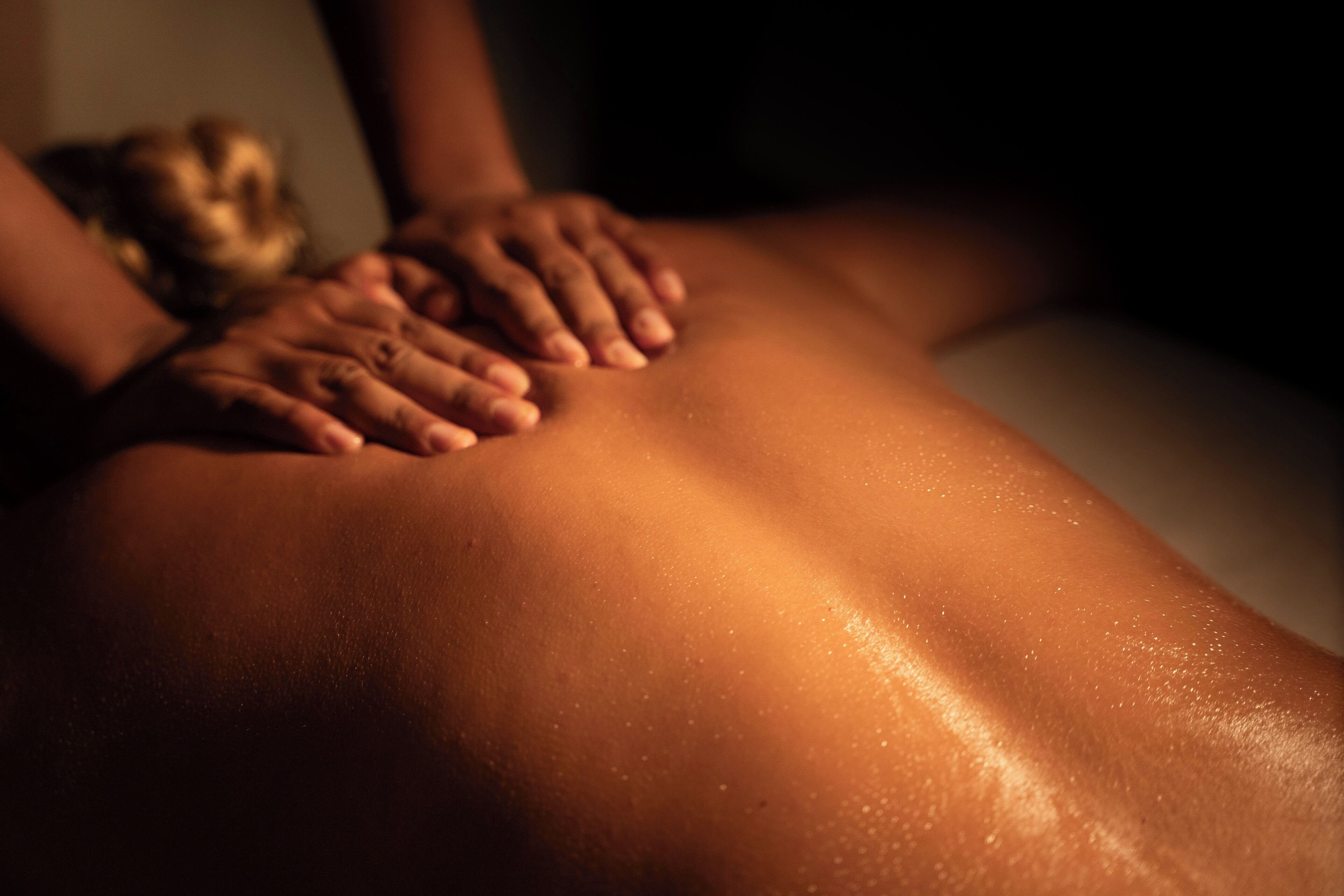 Nahaufnahme von Händen, die eine Rückenmassage geben.