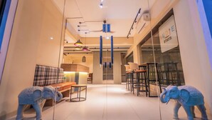 A hotel interior with a sofa, chairs, and elephant statues. -  Indie Stays Studio Kharadi (Pune)