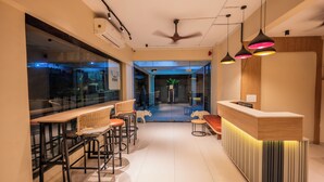 A modern interior with a reception desk, bar area, and seating. -  Indie Stays Studio Kharadi (Pune)