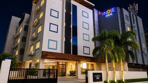 A multi-story hotel with a prominent 'INDIE STAYS' sign, a gated entrance, and a well-lit facade. -  Indie Stays Studio Kharadi (Pune)