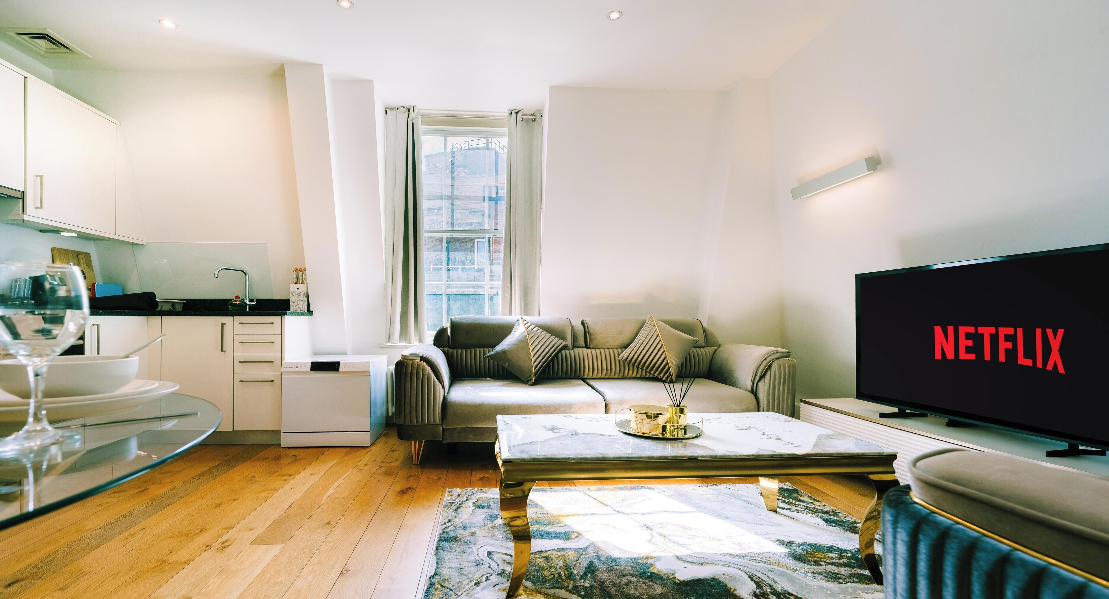 A modern living room with a sofa, coffee table, and a TV displaying 'NETFLIX'.