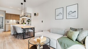 Un soggiorno moderno con un divano, un tavolino in vetro e un'area pranzo con tavolo e sedie.