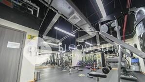 A gym with various exercise equipment, mirrors, and a black floor. - Bloomfields Cozy STU Balcony Leonardo (Abu Dhabi)