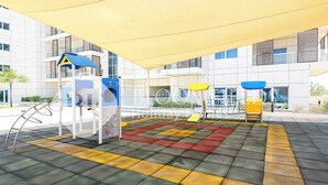 An outdoor play area with climbing structures and a yellow canopy. - Bloomfields Cozy STU Balcony Leonardo (Abu Dhabi)