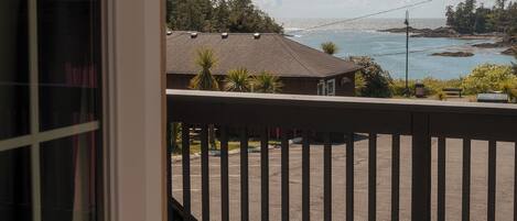 Une terrasse en bois offrant une vue sur l’océan et un bâtiment situé de l’autre côté de l’eau.