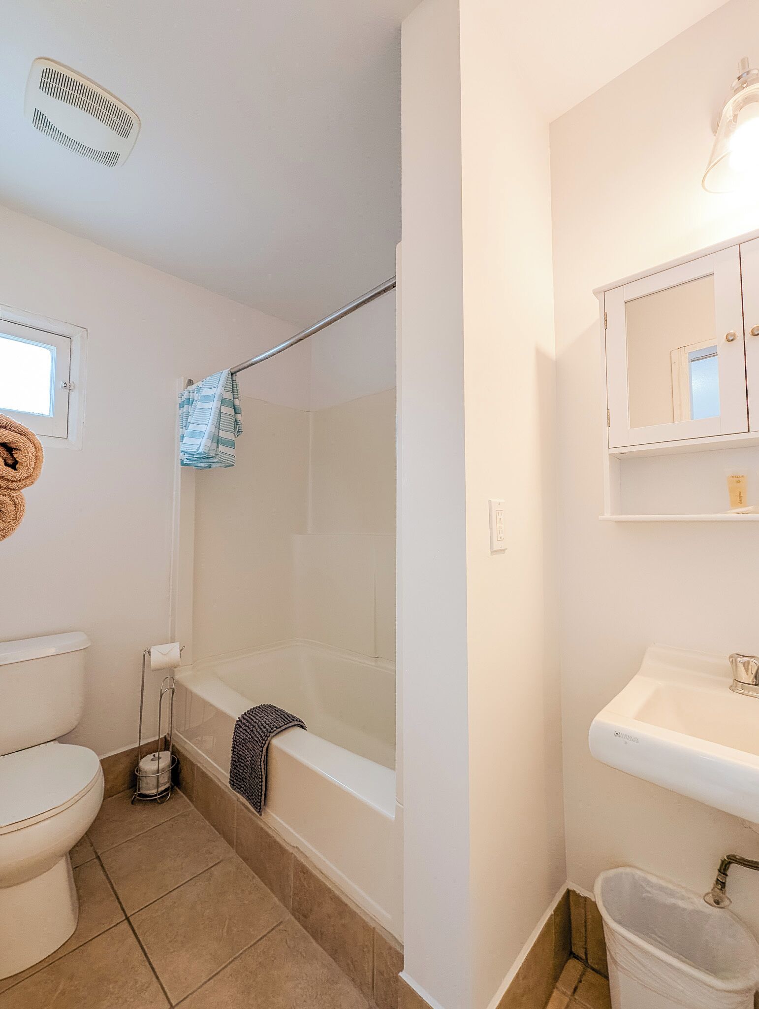 A bathroom with a toilet, bathtub, and sink.