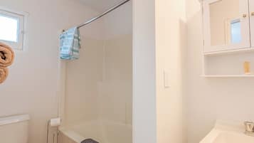 A bathroom with a toilet, bathtub, and sink.