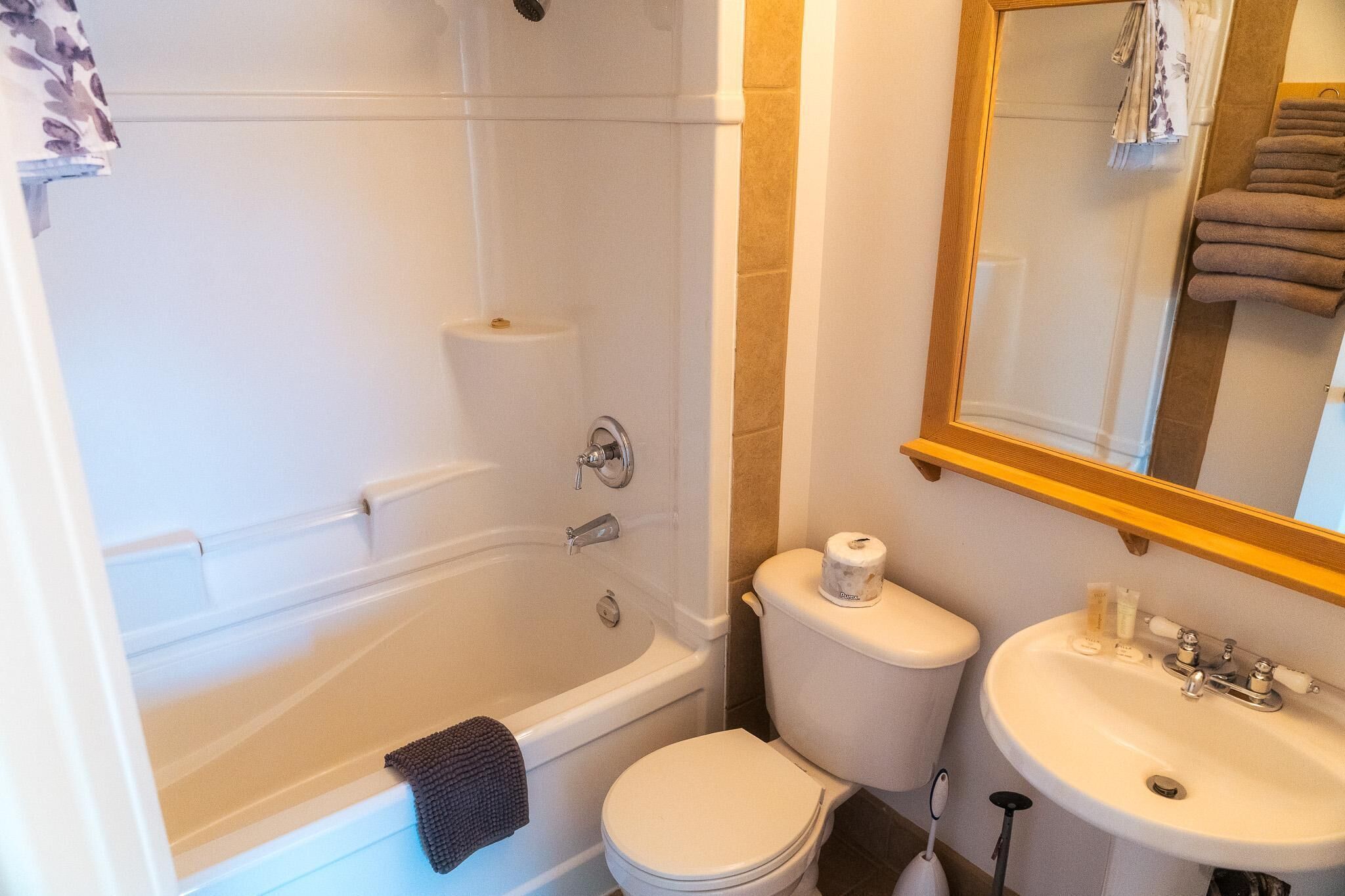 A bathroom with a bathtub, toilet, and sink.
