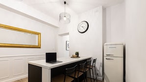 A compact kitchen with a white countertop, a laptop, a refrigerator, and a clock on the wall. - Verde 5 Pok j Wifi Dolny Gda sk (Gdansk)