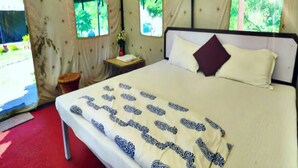 A tented room with a bed, a nightstand, and a window. - Eden RiverSide Camp (Lansdowne)