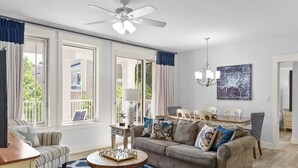 A spacious living room with a sofa, armchairs, a coffee table, and a dining area with chairs.