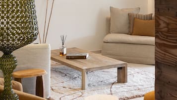 A living room with a sofa, coffee table, and decorative lamps.