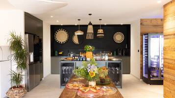 A modern kitchen with a central island, pendant lighting, and a wooden accent wall.