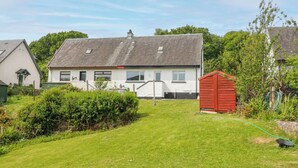 A white house with a grey roof, a red shed, and a well-maintained lawn. - 3 Whin Bank (Oban)