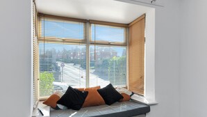 A room with a built-in bench at a window, featuring a view of the outside.