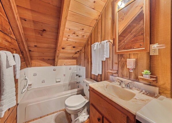 A wooden cabin bathroom with a bathtub, toilet, sink, and a mirror. - 2 BR  2 BA Cabin, Private, Close to Town, Covered Porch, Views, Gravel Access (Maggie Valley)