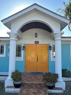 Stunning entrance with a central doorway, flanked by white columns and ornate details.