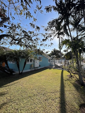 Stunning single-story home with a front porch, set amidst a lush lawn and shaded by mature trees.
