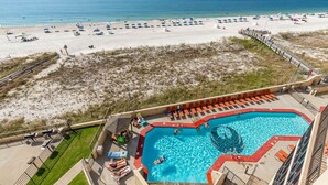 A rooftop pool with a view of the beach, lounge chairs, and a small play area. - Phoenix Iii 3059 3 Bedroom Condo (Orange Beach)