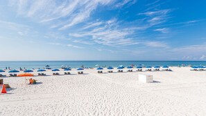 Relax on the pristine white sand beach with comfortable lounge chairs and beach umbrellas.