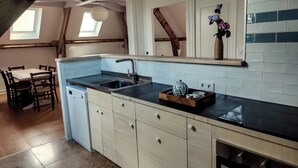 A kitchen with a central island, a built-in oven, and a window above the sink. - Gîte Prétanie - Pondside healthy lodging in lively Piégut-Pluviers (Piégut-Pluviers)
