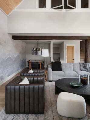 Ein modernes Wohnzimmer mit einer Couch, einem Couchtisch und einem Essbereich mit Tisch und Stühlen.