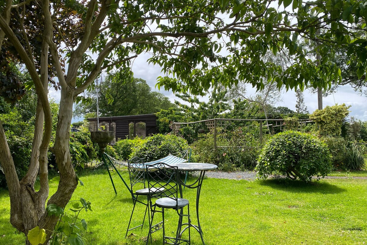A garden with a swing chair and a small table.