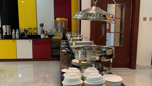 Un buffet avec plusieurs points de service et un présentoir central pour les plats.