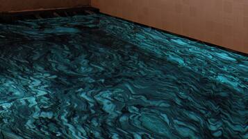 Una piscina techada, sillones reclinables de piscina