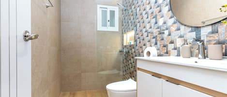 Et stilfuldt badeværelse med bruser, toilet og håndvask.