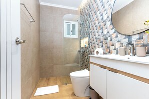 A modern bathroom with a shower, toilet, and vanity. - Casual Green Village Bayahibe by Casual Hoteles (Bayahíbe)