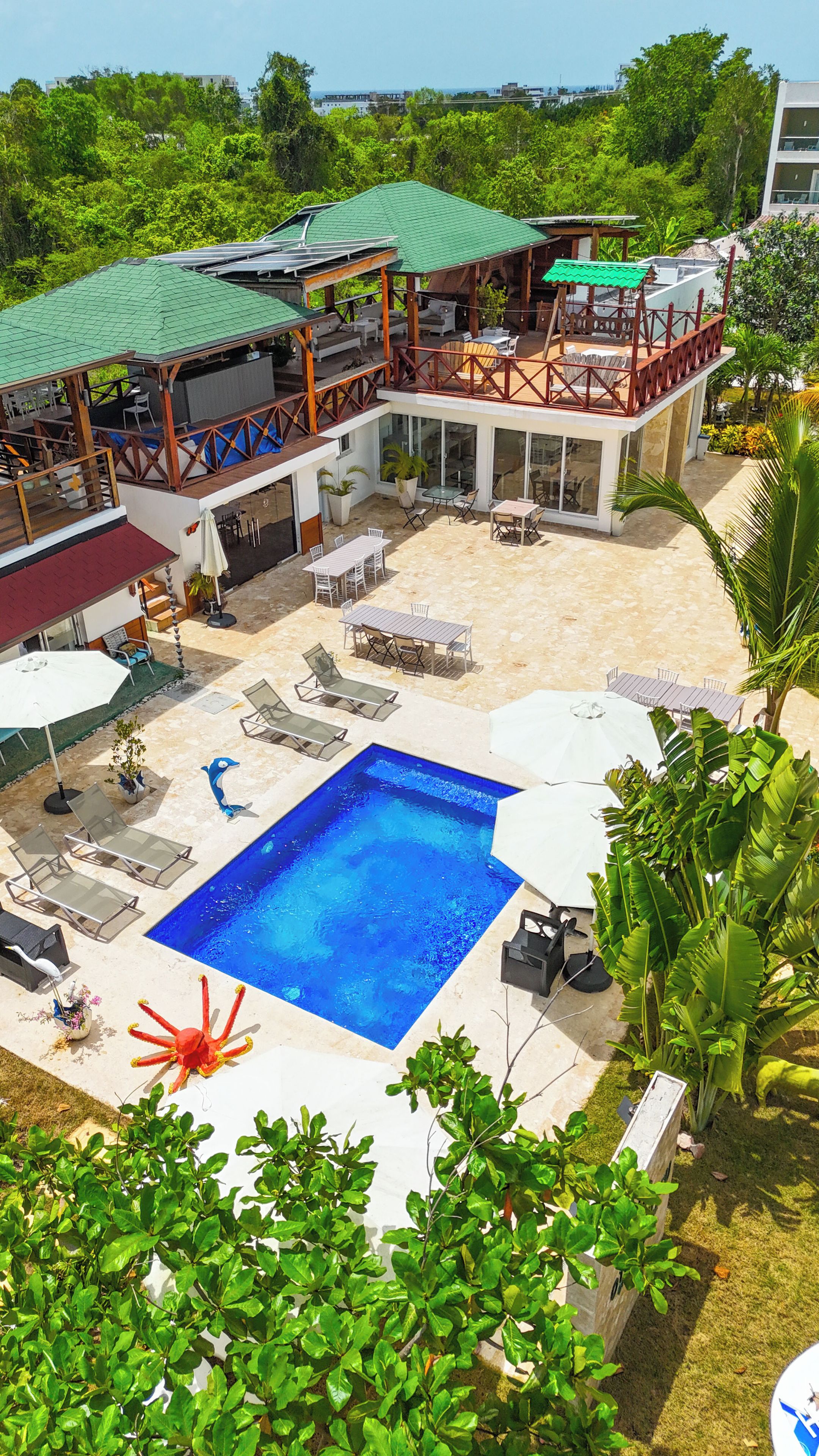 Un resort con piscina, mobiliario exterior y una zona de patio cubierta.