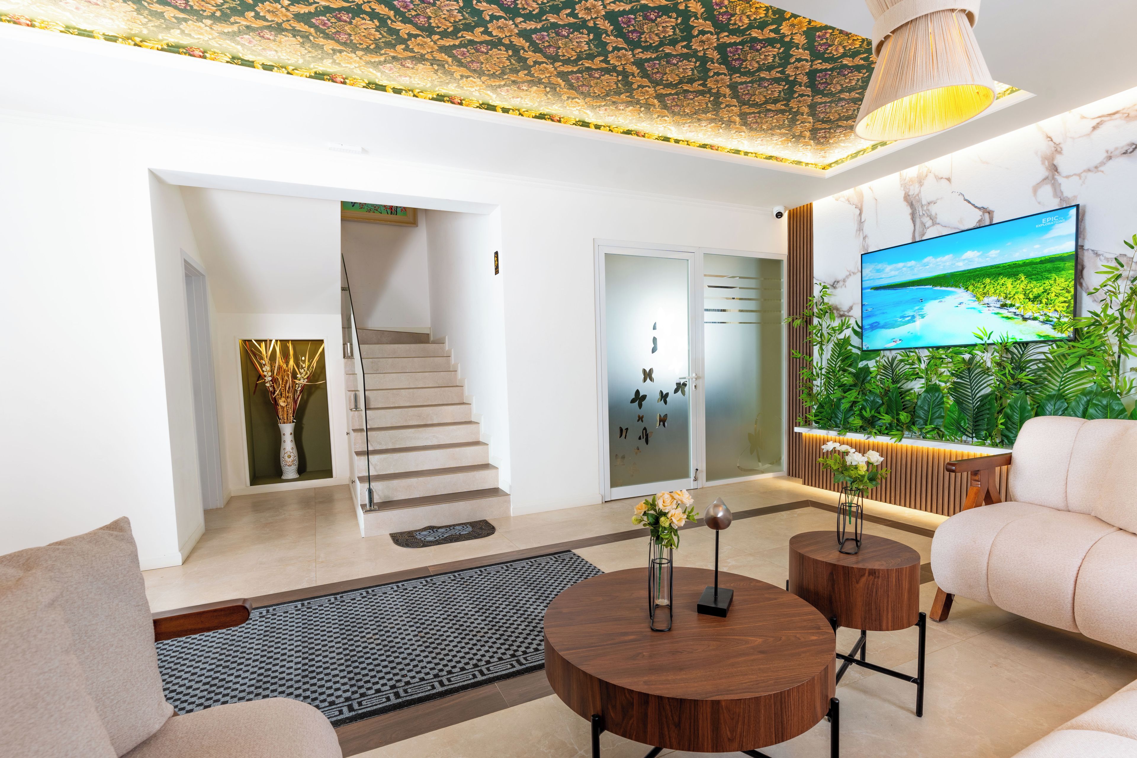 Een moderne woonkamer met een bank, een salontafel, een televisie en een trap naar een andere kamer.