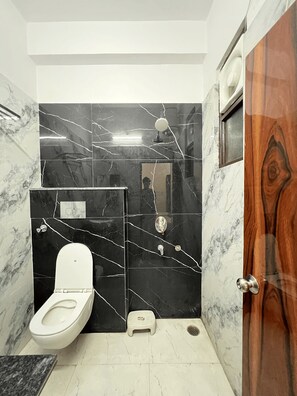 Deluxe-dobbeltværelse - byudsigt | Badeværelse | Bruser, gratis toiletartikler, hjemmesko, håndklæder
