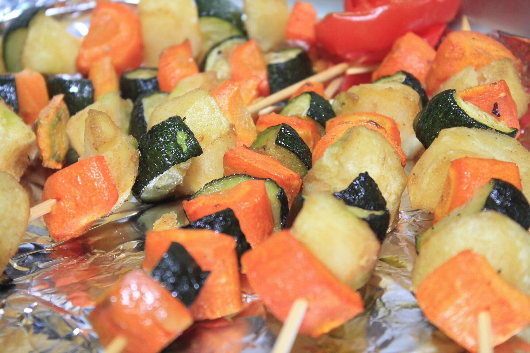 Skewers of vegetables on foil.