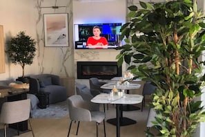 A modern living room with a fireplace, comfortable seating, and a television.