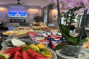 Enjoy a delicious spread of fresh fruits, cheeses, and pastries, along with a variety of beverages, in this hotel room.