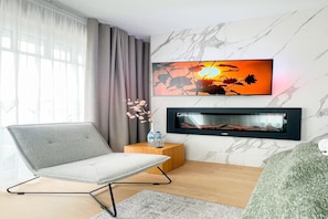 Relax in this stylish living room with a comfortable armchair, flat-screen TV, and cozy fireplace.