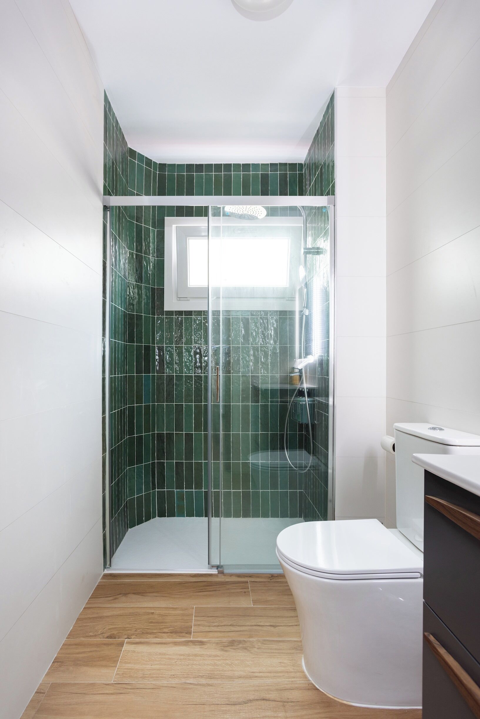Un baño con cabina de ducha, inodoro y lavabo.