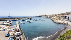 Un puerto con barcos amarrados, un muelle y edificios a lo largo de la costa.