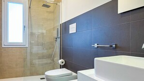 A modern bathroom with a shower, two toilets, and a large mirror above the sink. - Tevergad Suite & Rooms (Terrasini)