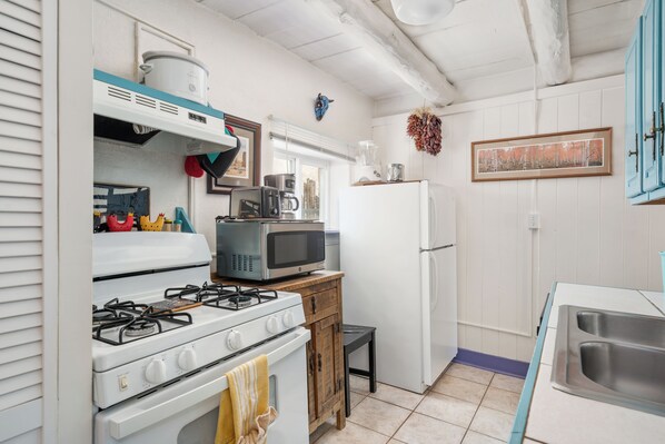 A compact kitchen with a gas stove, microwave, and white refrigerator. - La Casita Berger - Minutes away from Plaza and Canyon Rd (Santa Fe)