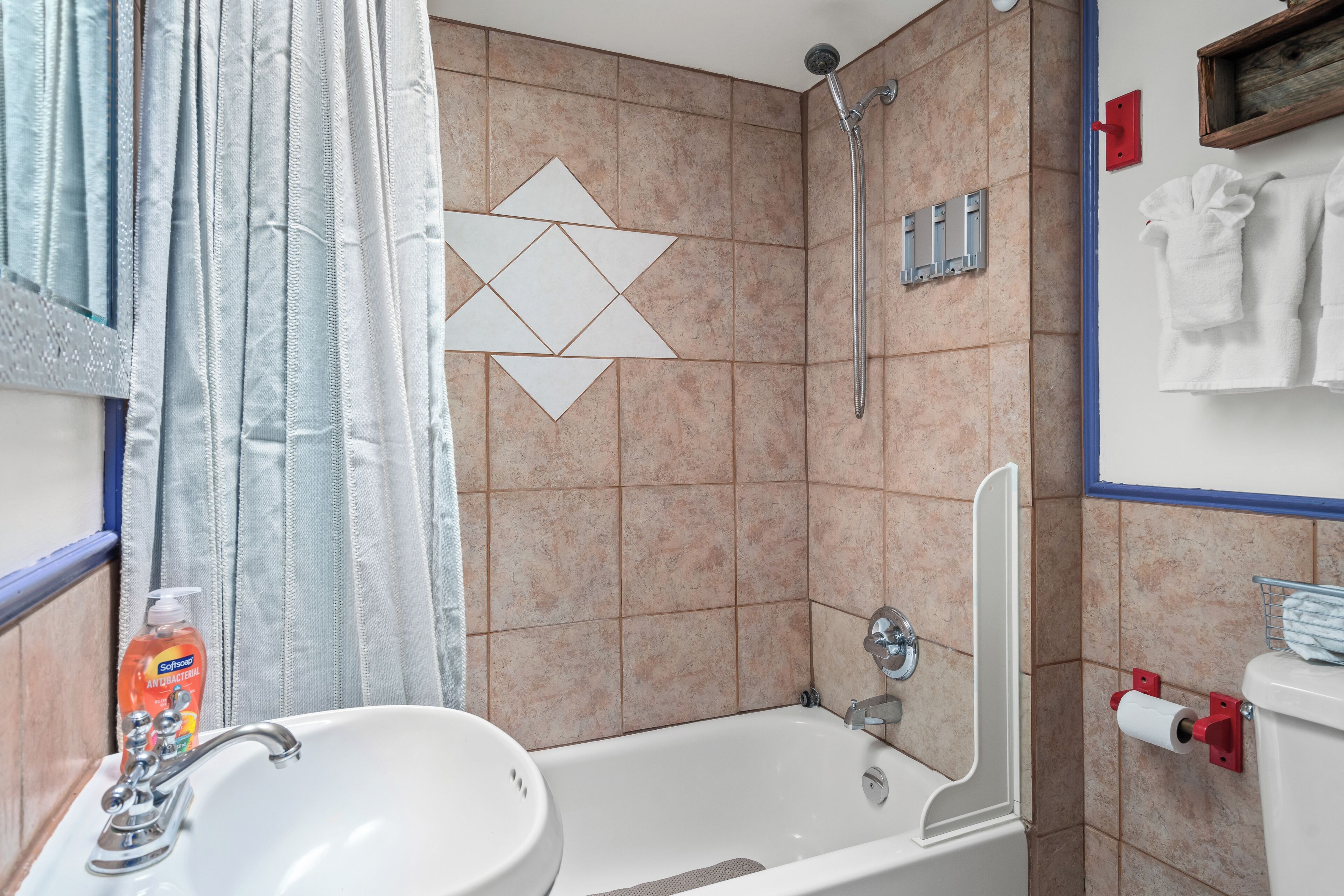 Een badkamer met een wastafel, douche en toilet.