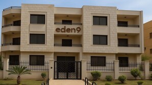 A multi-story building with the name 'eden9' displayed prominently. It features a symmetrical facade with evenly spaced windows and balconies.
