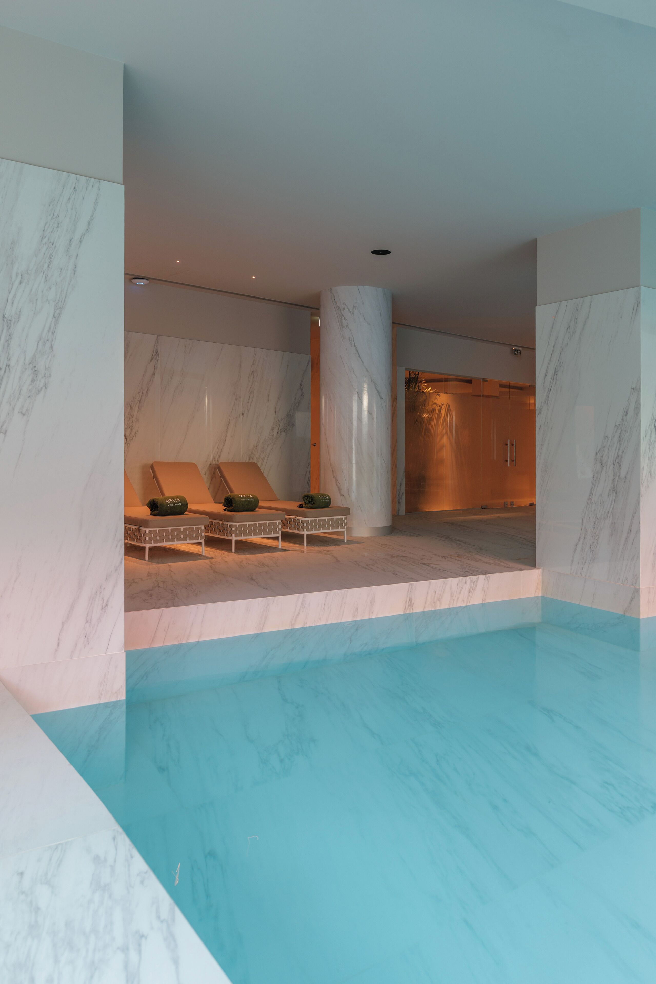 Een binnenzwembad, een buitenzwembad, parasols voor strand/zwembad