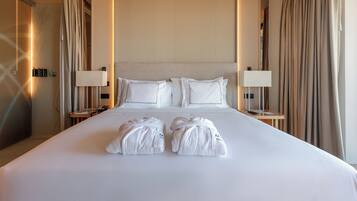 Une chambre d’hôtel avec un grand lit, deux tables de chevet, deux lampes et deux serviettes sur le lit.