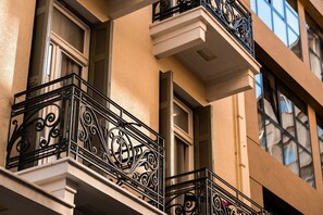 A building facade with ornate black wrought iron balconies and large windows.