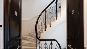 A staircase with a dark wooden finish and a metal railing. - Asty Luxury Apartments (Athens)