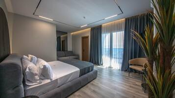 Suite júnior, balcó, vistes al mar | Minibar, caixa forta a l'habitació, escriptori i cortines opaques